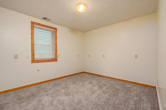 carpeted empty room featuring a textured ceiling