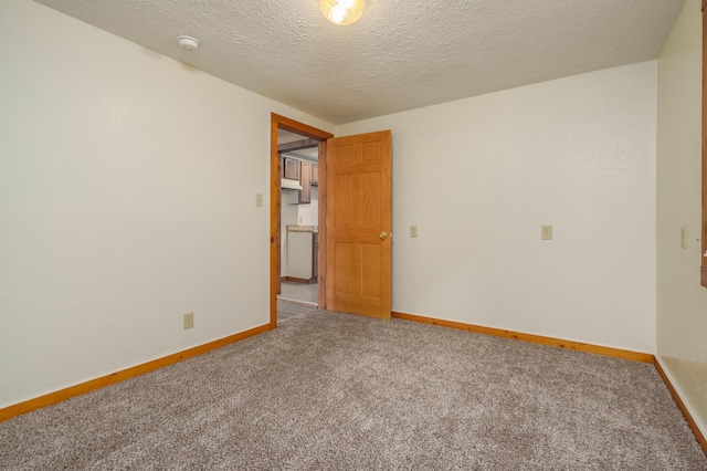 spare room featuring a textured ceiling and carpet floors