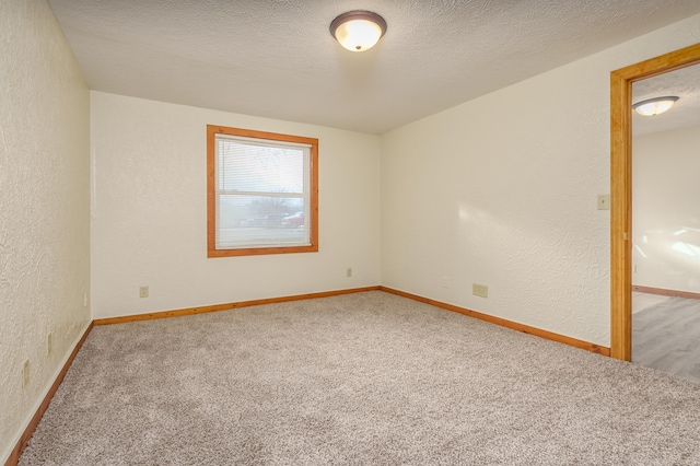 unfurnished room featuring carpet flooring and a textured ceiling