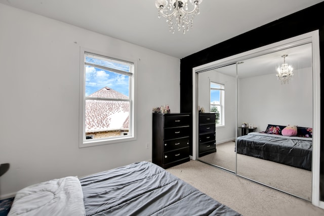 carpeted bedroom featuring a closet and a notable chandelier