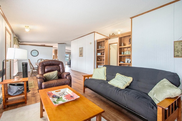 living room featuring hardwood / wood-style floors, lofted ceiling, and ornamental molding