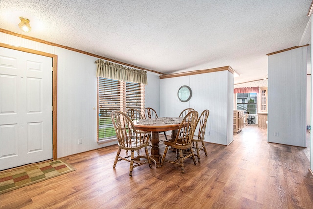 dining room featuring hardwood / wood-style floors, a textured ceiling, and ornamental molding