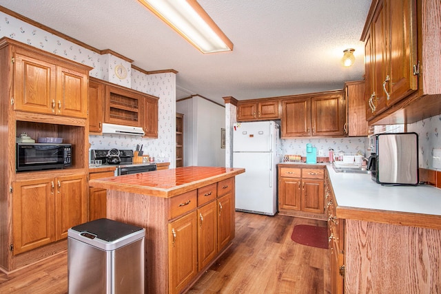 kitchen with a center island, black appliances, a textured ceiling, and light wood-type flooring