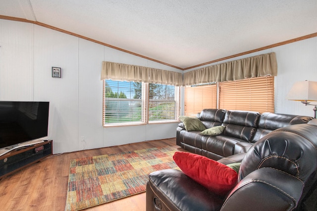 living room with a textured ceiling, light wood-type flooring, vaulted ceiling, and crown molding