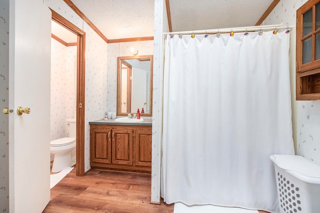 bathroom featuring vanity, a textured ceiling, crown molding, hardwood / wood-style flooring, and toilet