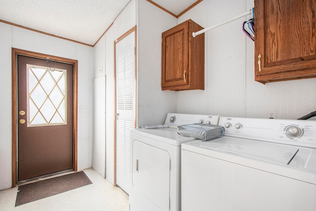 laundry room featuring cabinets, crown molding, washing machine and dryer, and a textured ceiling