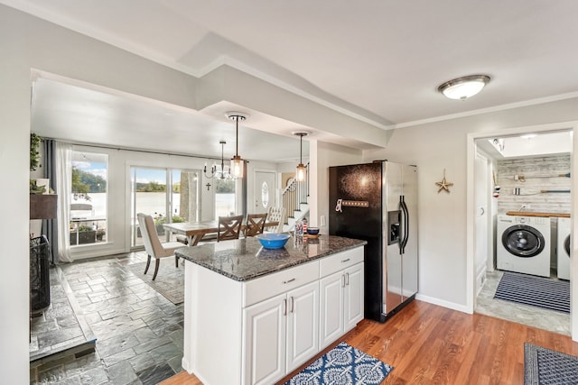 kitchen with white cabinetry, stainless steel refrigerator with ice dispenser, dark stone counters, washer and dryer, and hardwood / wood-style flooring