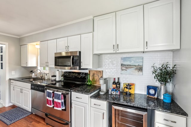 kitchen featuring stainless steel appliances, beverage cooler, sink, white cabinets, and hardwood / wood-style floors