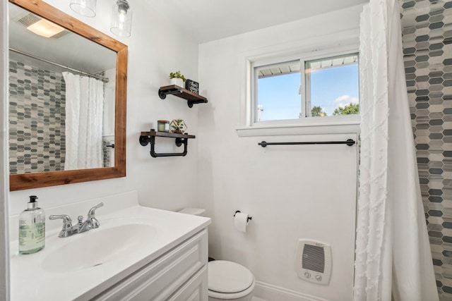 bathroom featuring a shower with shower curtain, vanity, toilet, and heating unit