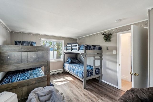 bedroom featuring baseboard heating and hardwood / wood-style floors