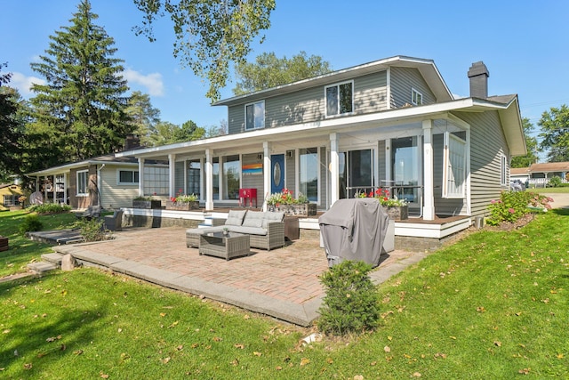 rear view of property with a lawn, an outdoor hangout area, and a patio