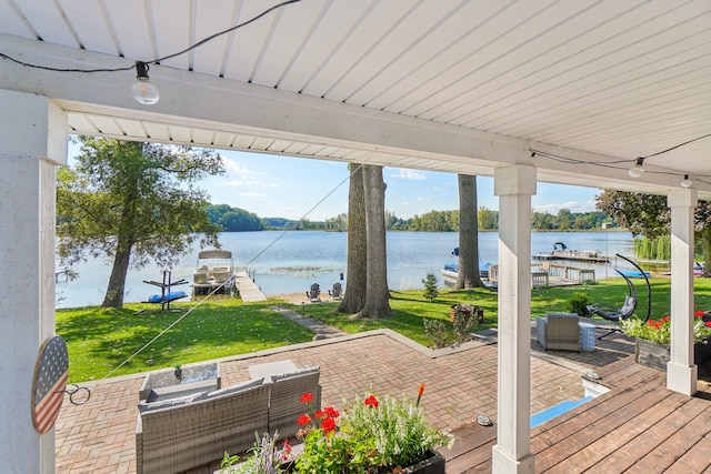 exterior space featuring outdoor lounge area, a patio, a water view, and a lawn