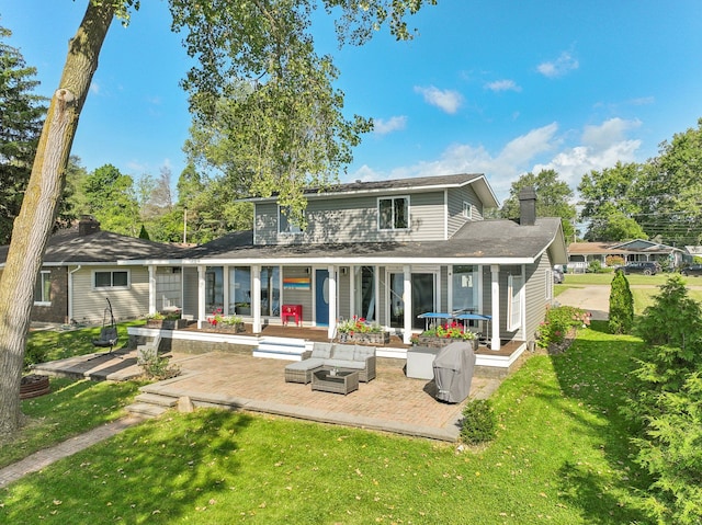 back of property featuring outdoor lounge area, a yard, and a patio area