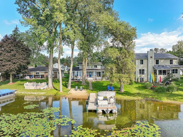 view of dock with a water view and a yard