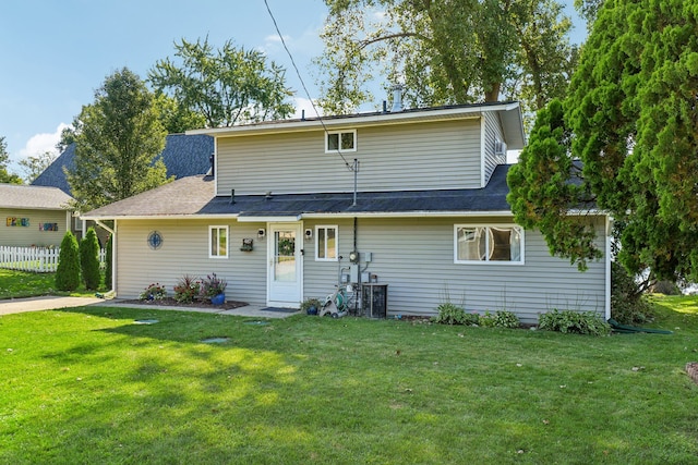 rear view of house featuring a lawn