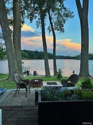 exterior space with a water view, a fire pit, and a patio area