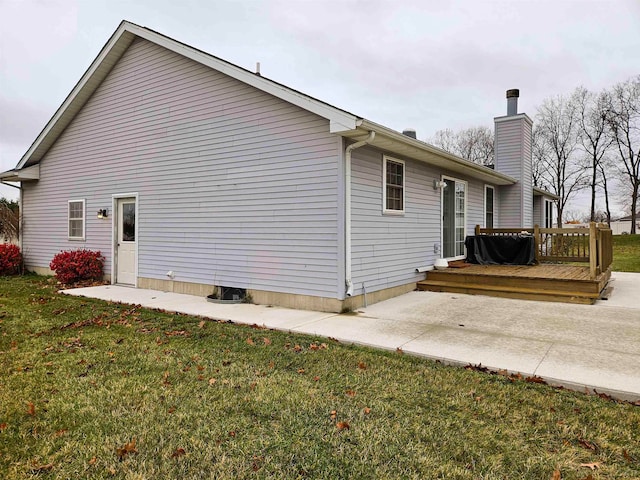 rear view of house with a deck, a patio, and a yard