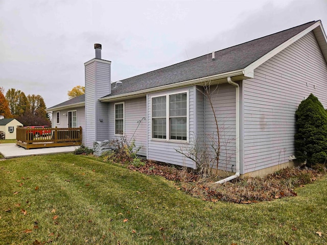 view of side of property featuring a yard and a wooden deck