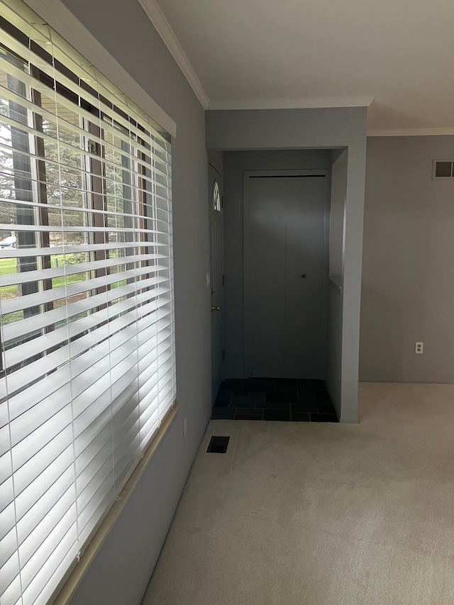 doorway to outside featuring dark colored carpet and ornamental molding