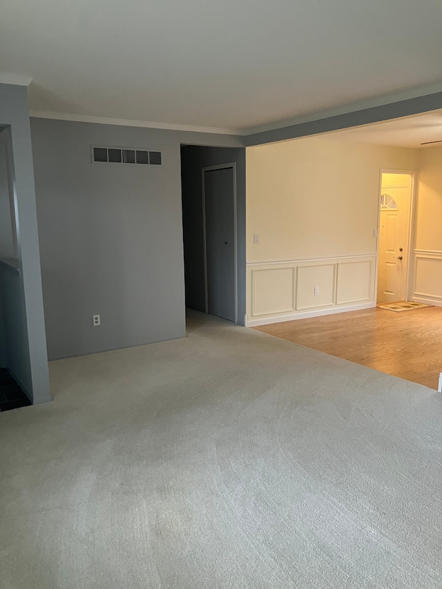 unfurnished room with light colored carpet and ornamental molding