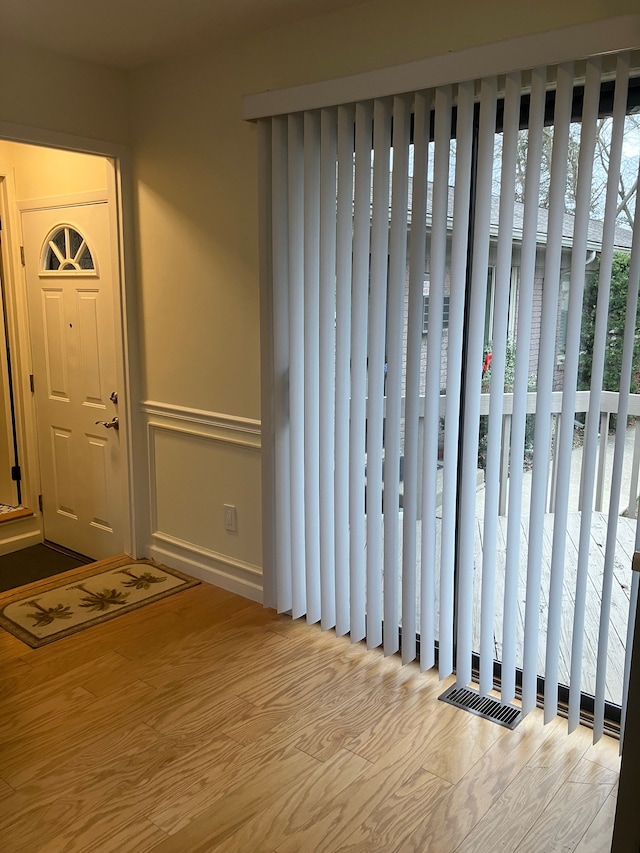 foyer entrance with light hardwood / wood-style flooring and a healthy amount of sunlight