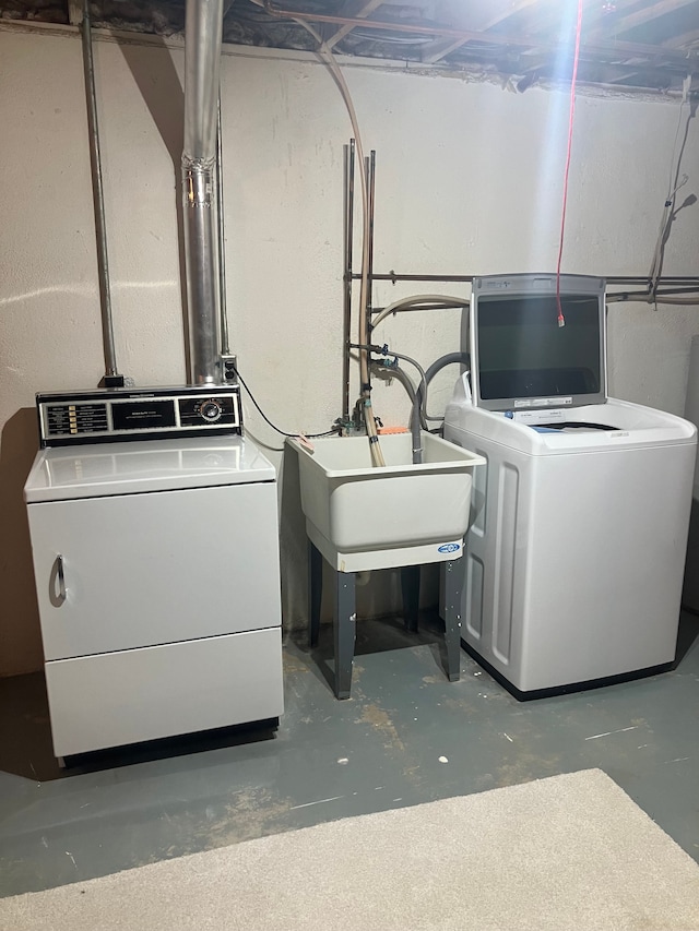 clothes washing area featuring sink and washing machine and clothes dryer