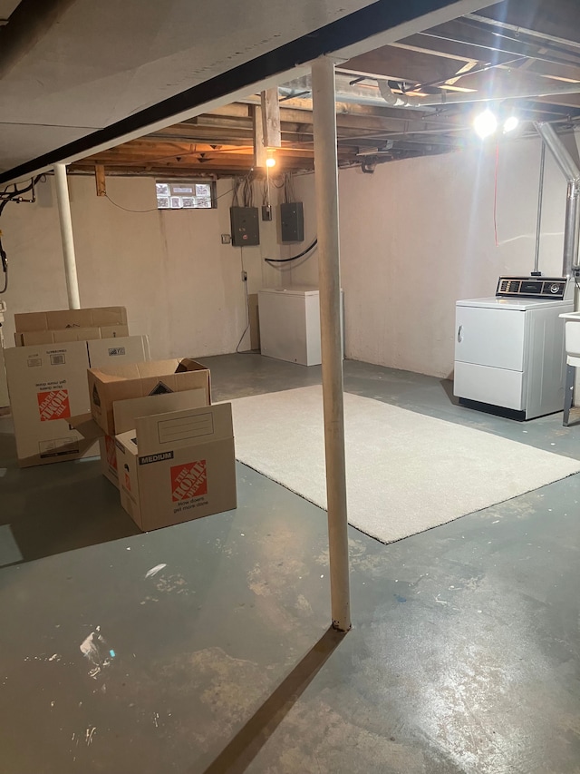 basement with electric panel and washer and clothes dryer