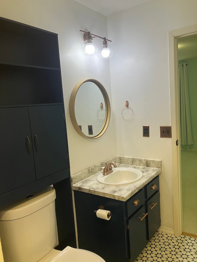 bathroom with tile patterned flooring, vanity, and toilet