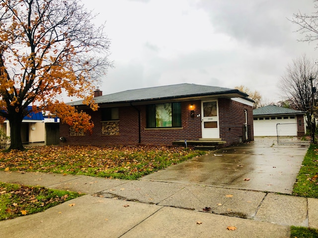 29161 Schoenherr Rd, Warren, MI 48088 - view of front of house with an outdoor structure, brick siding, a detached garage, and a chimney