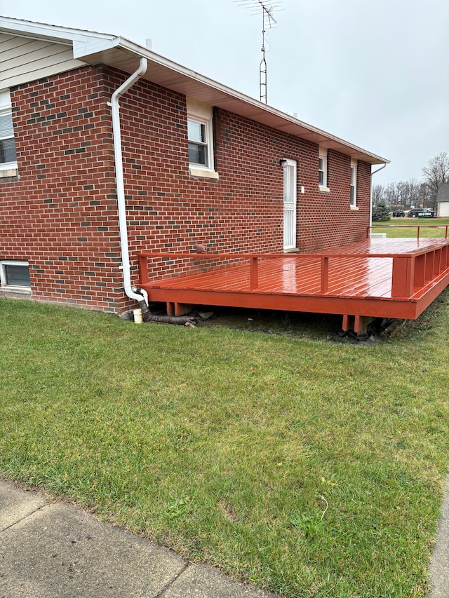 back of property with a wooden deck and a yard