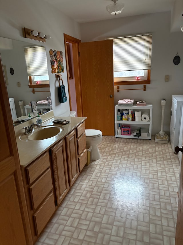 bathroom with vanity, toilet, and a healthy amount of sunlight