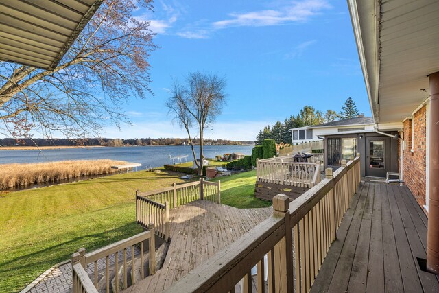 wooden terrace with a lawn and a water view