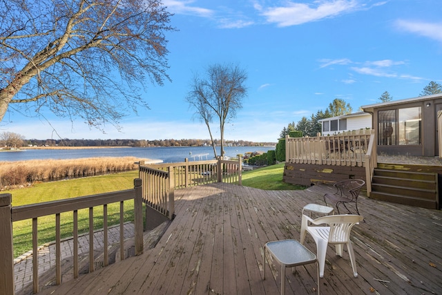 deck featuring a water view and a lawn