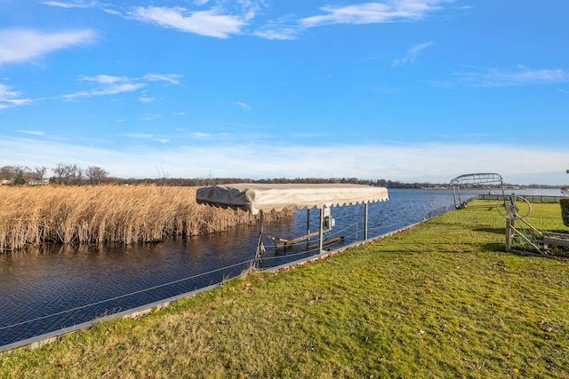 view of dock featuring a water view and a yard