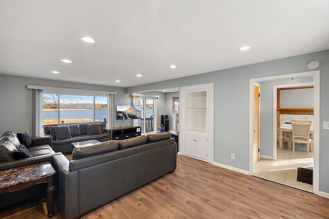 living room with light hardwood / wood-style flooring and a textured ceiling