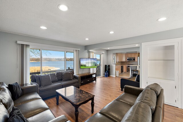 living room featuring a textured ceiling and light wood-type flooring