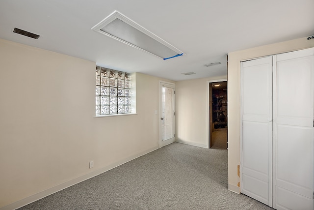 interior space with visible vents, light colored carpet, and baseboards