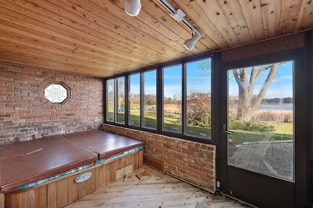 unfurnished sunroom with track lighting and wood ceiling