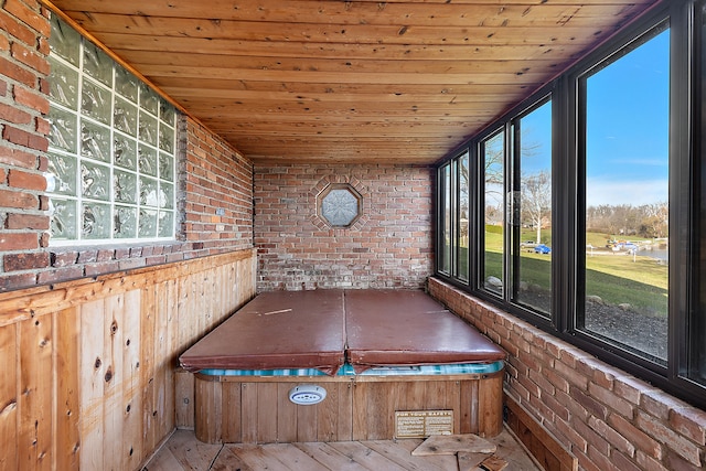 unfurnished sunroom featuring a hot tub, plenty of natural light, and wood ceiling