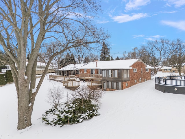 view of front of property featuring brick siding and a wooden deck