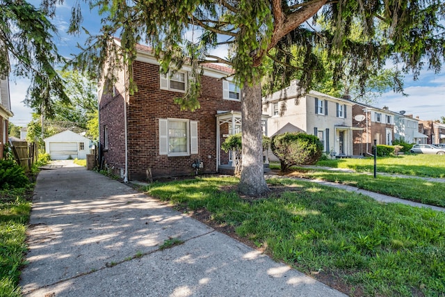 townhome / multi-family property featuring a front yard, a garage, and an outdoor structure