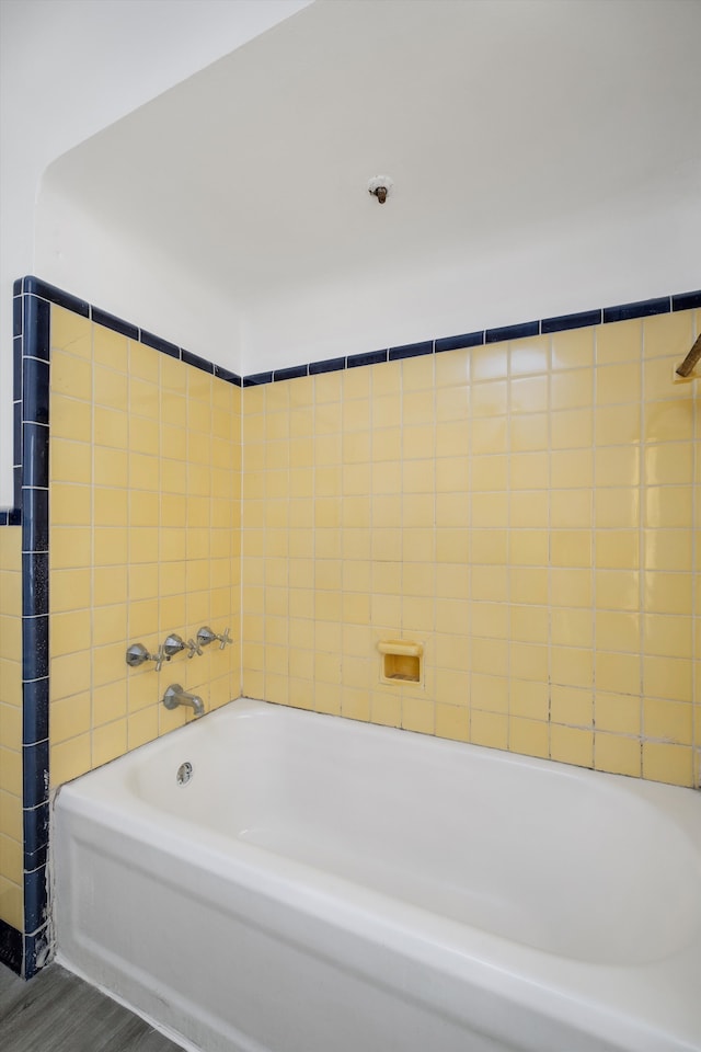 bathroom with a bathing tub and hardwood / wood-style flooring