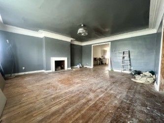 unfurnished living room featuring hardwood / wood-style floors and ornamental molding