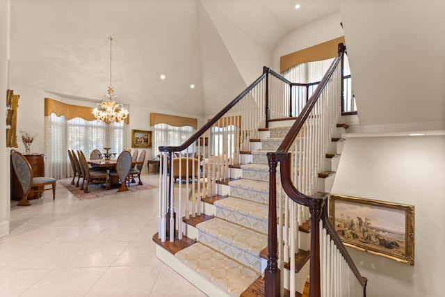 stairs featuring tile patterned flooring, high vaulted ceiling, and a notable chandelier