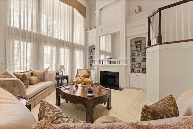 carpeted living room featuring built in shelves and a towering ceiling