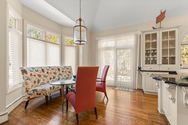 dining area with baseboard heating, lofted ceiling, and hardwood / wood-style flooring