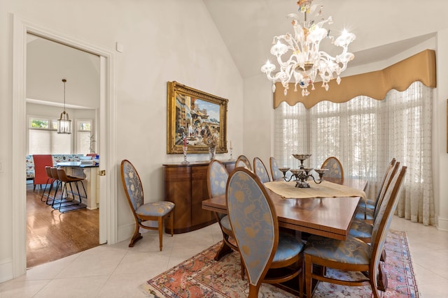 dining room featuring a notable chandelier, high vaulted ceiling, and light hardwood / wood-style flooring