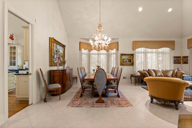 dining room with light wood-type flooring, lofted ceiling, a healthy amount of sunlight, and a notable chandelier