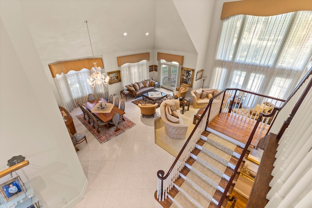 living room featuring light tile patterned flooring, high vaulted ceiling, and an inviting chandelier