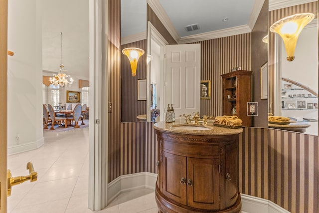 bathroom with tile patterned flooring, vanity, ornamental molding, and an inviting chandelier